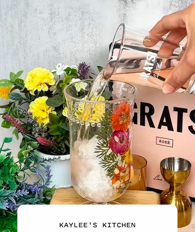 Kaylee in the kitchen pouring a glass of Gratsi Rosé into a spritz on ice