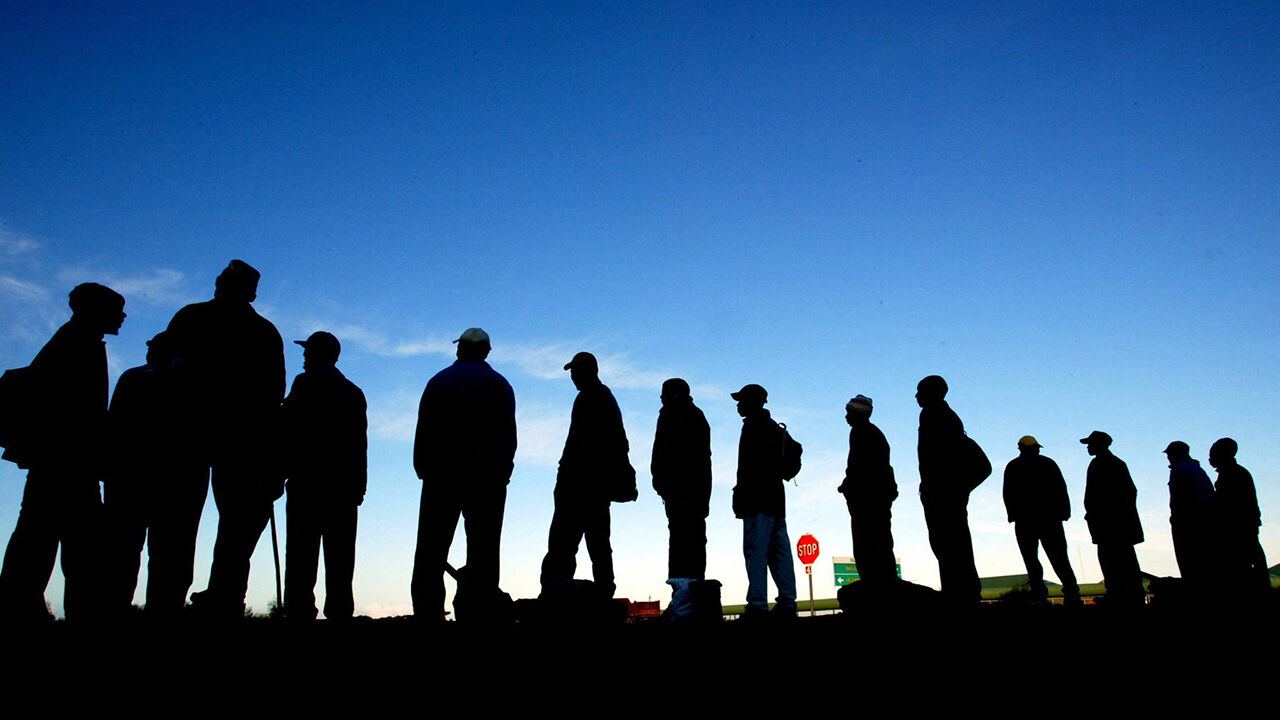 Job seekers wait for work beside the road near Cape Town's Khayelitsha township 