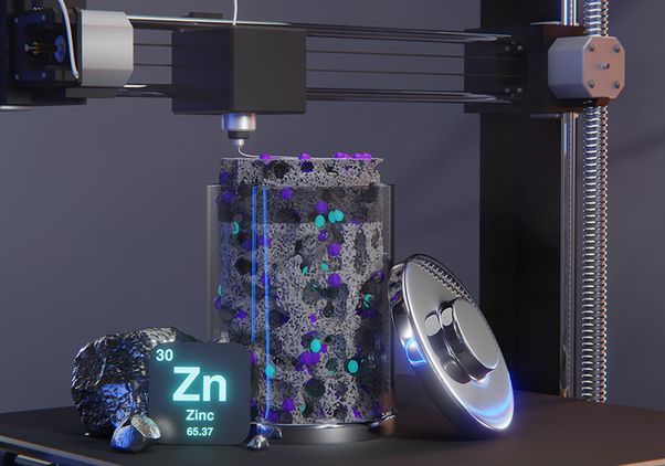 Close-up illustration of a 3D printer depositing material into a transparent container filled with a porous structure and colorful particles. A zinc element icon and metallic zinc samples in the foreground suggest zinc-based additive manufacturing or materials research.