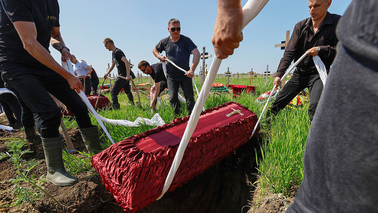 A coffin is lowered into the ground - as people take part in a funeral ceremony to bury the remains of 60 Russian soldiers and 3 civilians, killed in the course of Russia-Ukraine conflict, at a cemetery in Luhansk, Russian-controlled Ukraine.