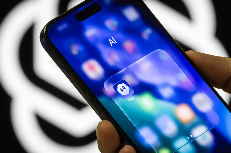 In this photo illustration, the Sora app icon is seen inside an AI folder on a smartphone screen in front of the OpenAI logo.