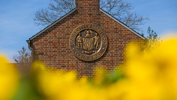 UMD Founder's Gate with yellow flowers in foreground