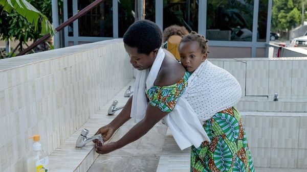 A woman washes her hands at the Rwandan border following confirmation of an Ebola outbreak in Congo