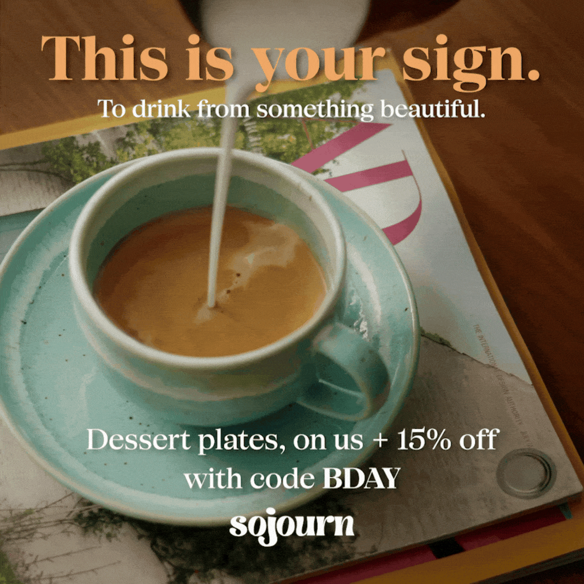 Coffee being poured into a teal cup with a magazine in the background.