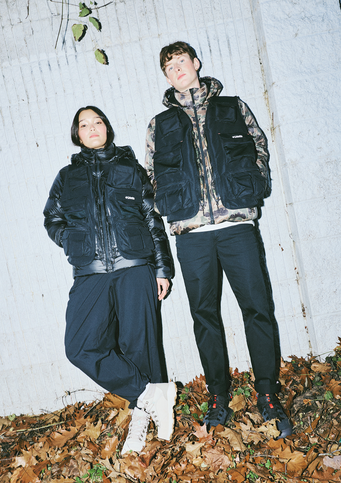 Man and woman posing in CSC1938 gear standing on top of foliage.