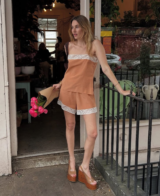Woman wearing a two piece lace camisole set holding flowers