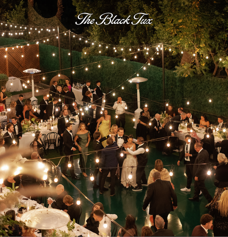 Overhead view of an outdoor wedding reception with string lights, guests dining, and couples dancing under the lights.