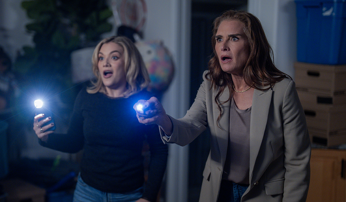 Two shocked women holding flashlights.